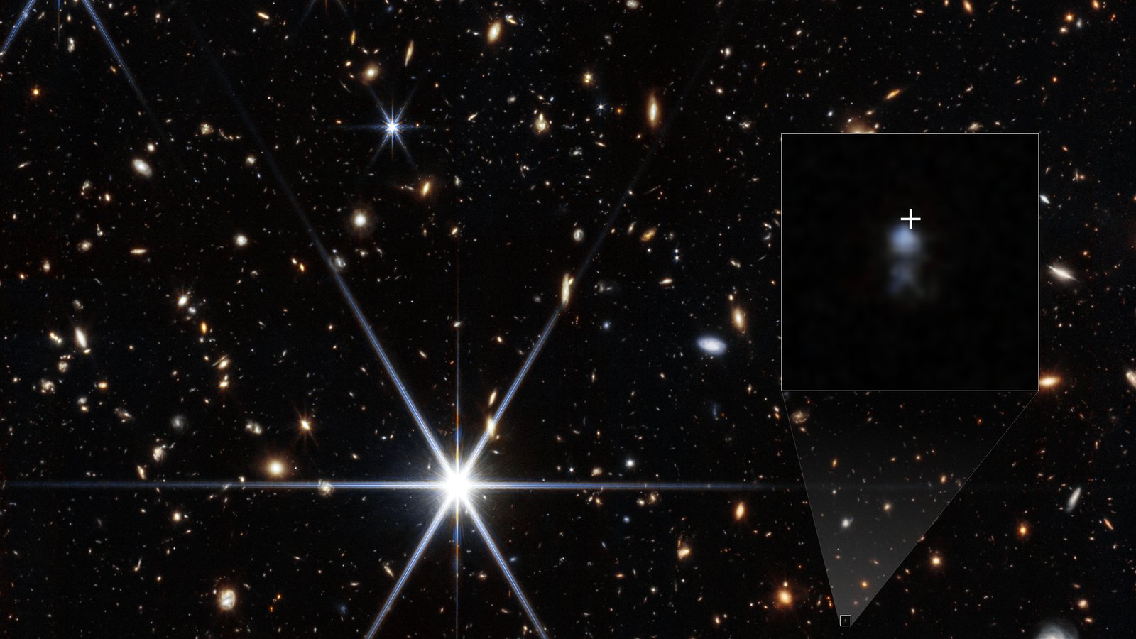 Webb NIRCam deep field full of small orange and white galaxies and a few bright spiky stars; an inset box on the right zooms in on a faint bluish smudge, the burst’s host galaxy, with a white cross marking where the radio burst came from
