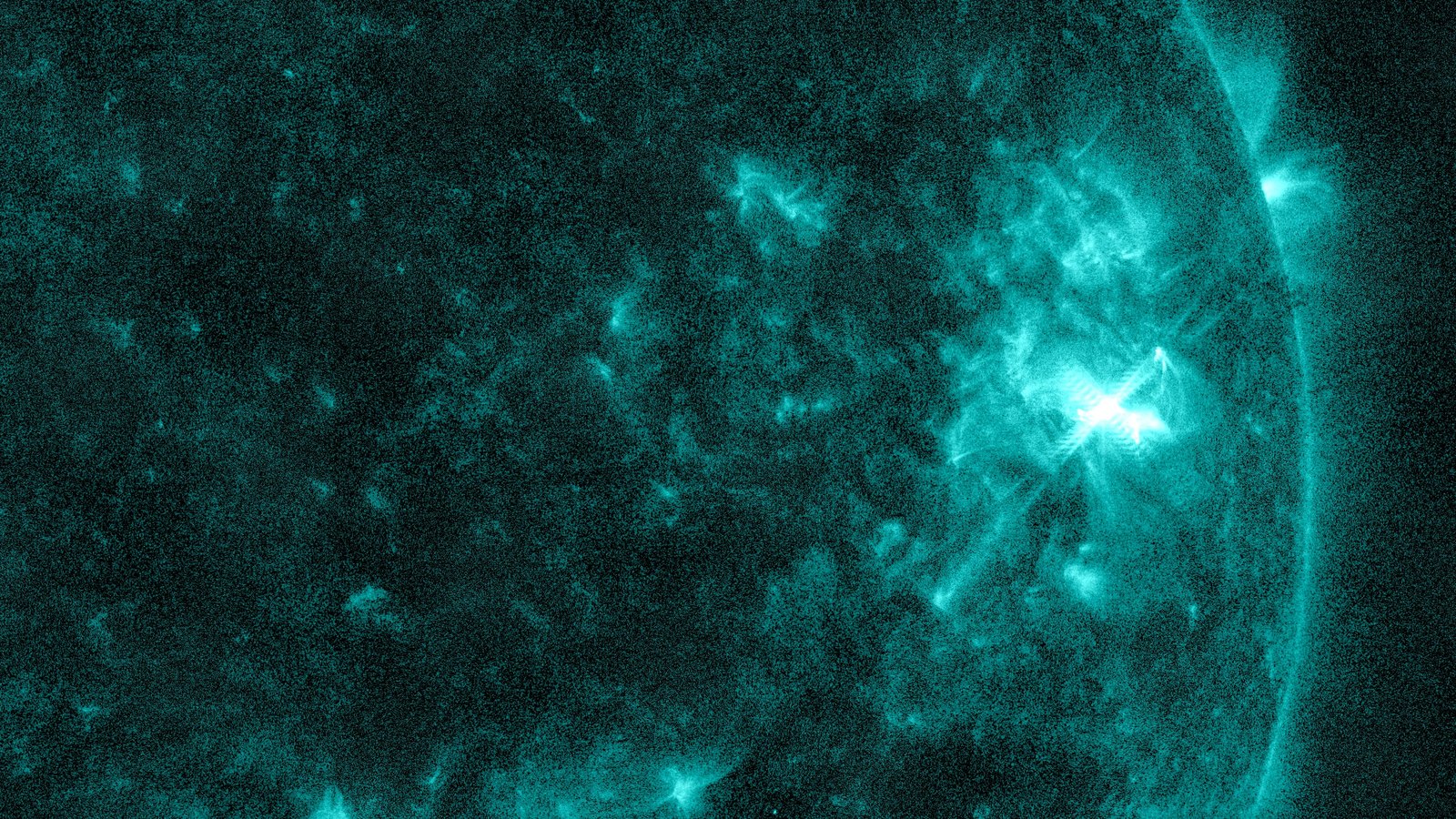 Close-up of the Sun in teal extreme-ultraviolet light from NASA’s Solar Dynamics Observatory, with a bright white M6.4 flare in sunspot Region 4549 near the Sun’s right edge, Oct. 10, 2026