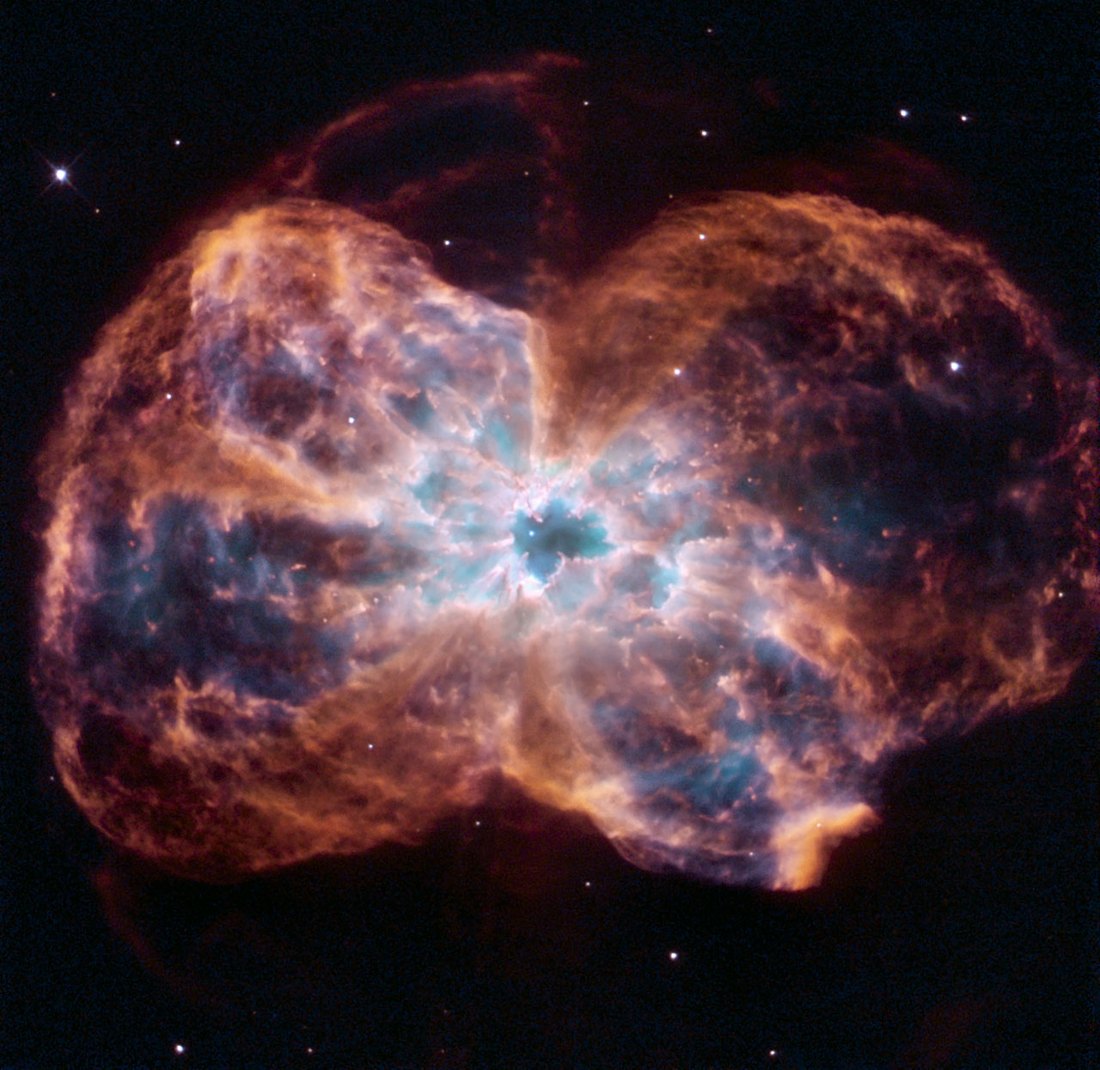 Hubble image of planetary nebula NGC 2440, glowing clouds of gas around a white dot, the white dwarf at its center