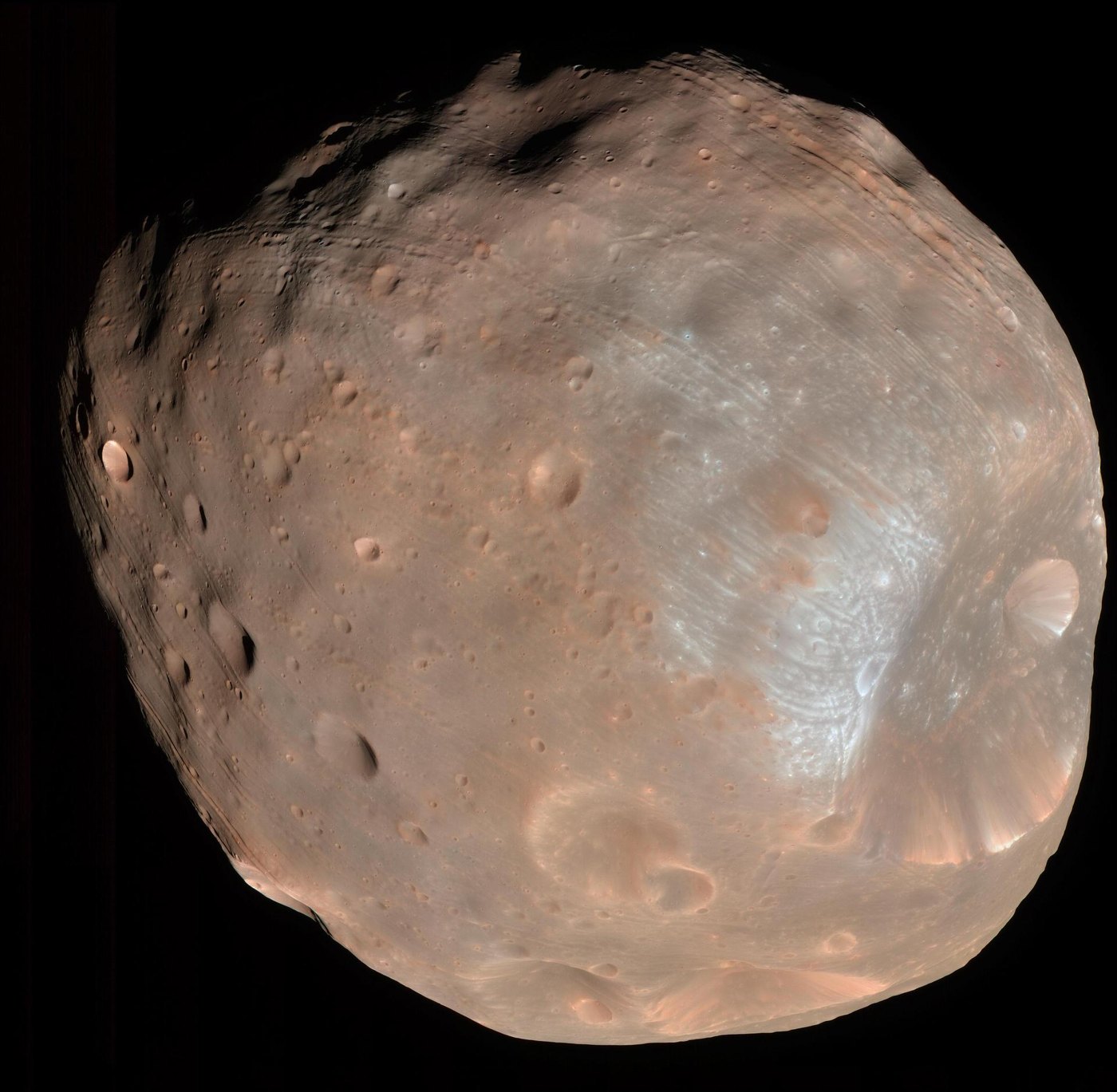 Color view of Phobos, a lumpy, reddish-grey moon covered in craters, against black space