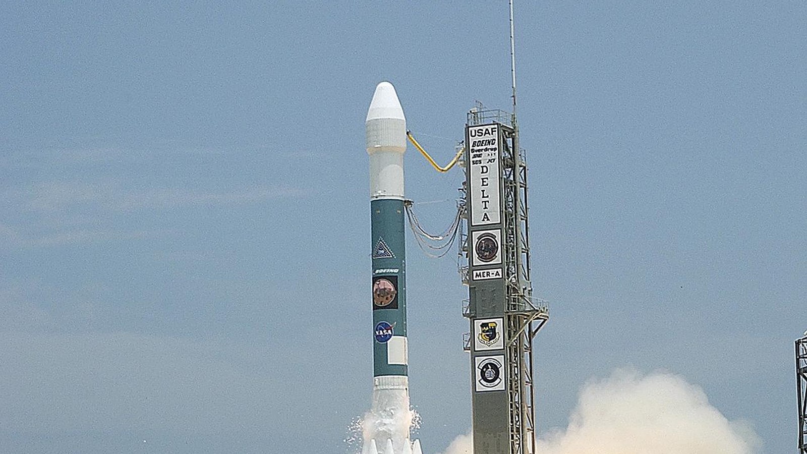 Rocket climbing into a clear blue sky at liftoff