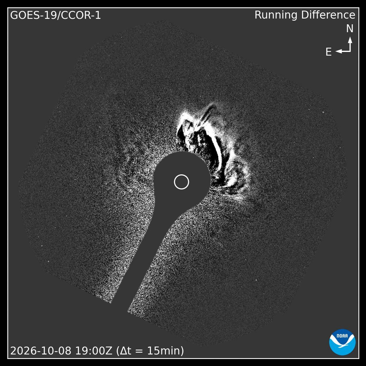 Black-and-white running-difference coronagraph frame from GOES-19 CCOR-1, with a bright, ragged cloud of material expanding above the upper right edge of the blocked-out Sun