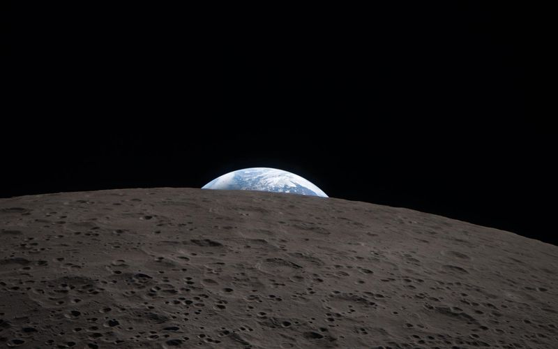 Earth rising above the curved gray surface of the Moon, seen by the Artemis II crew — NASA