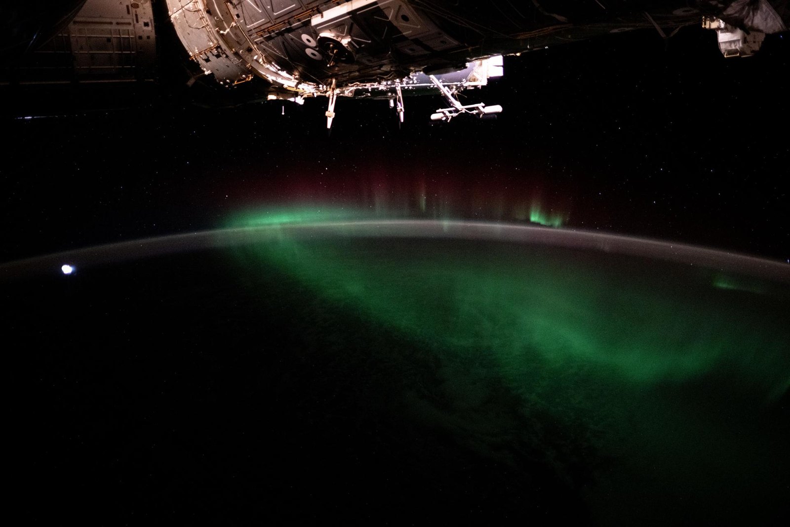 Green aurora australis curving over the dark Indian Ocean horizon, seen from the International Space Station