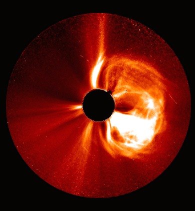 Coronagraph image of a bright orange cloud of solar material erupting to the right of the dark central disk that blocks the Sun